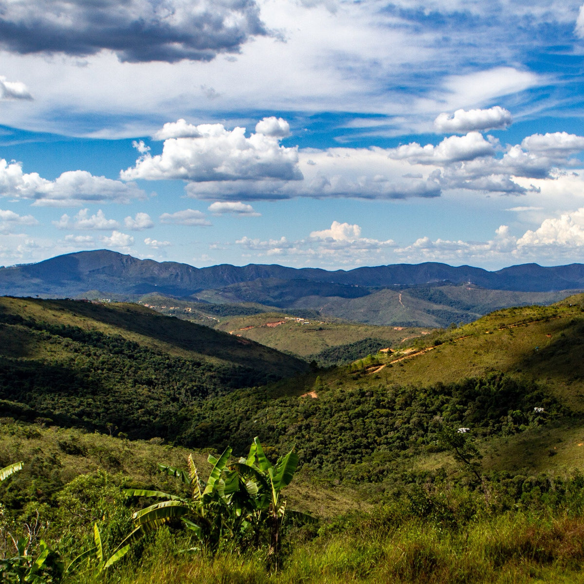 Serras de Sabará, Minas Gerais, vistas do alto, com vale verde e céu azul com nuvens